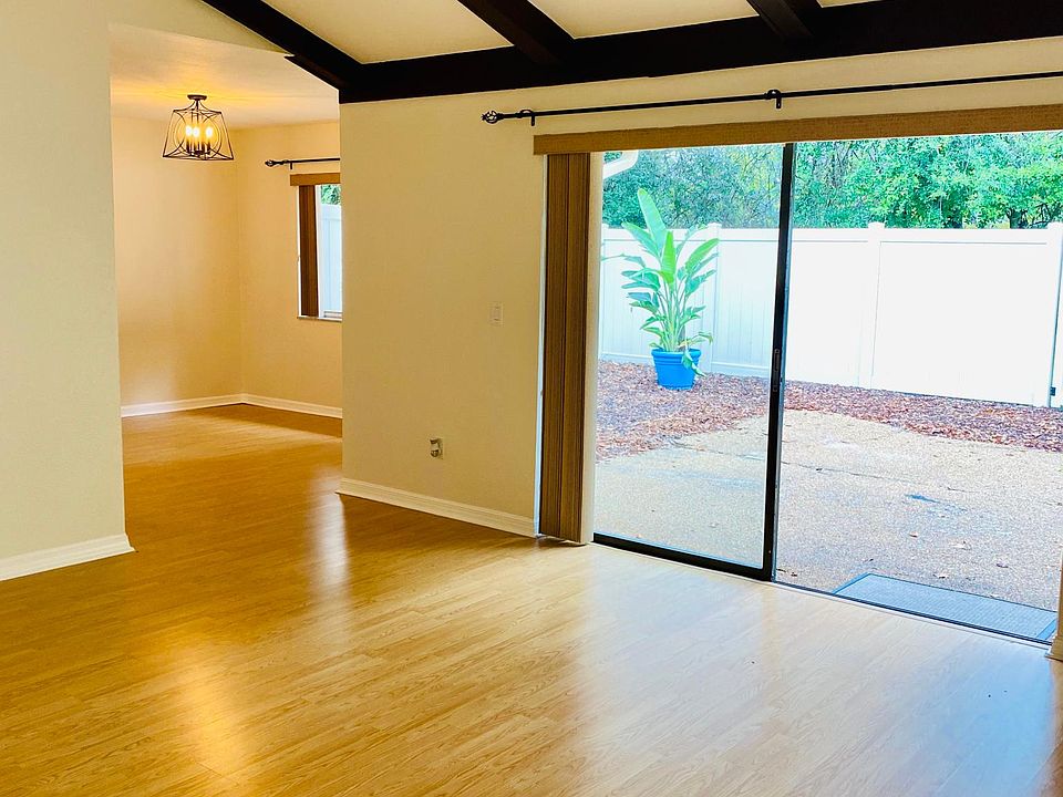 Spacious living room with vaulted beam ceiling opens onto your outdoor garden patio.