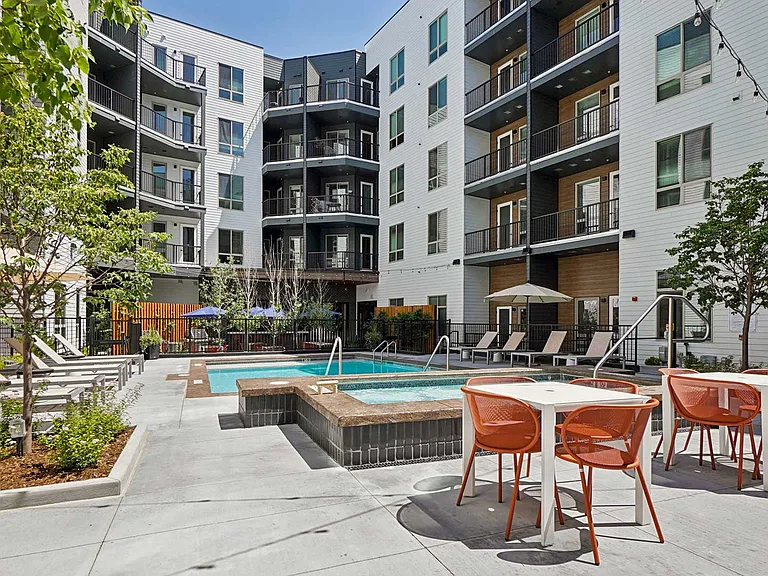 Enjoy sunny afternoons and relaxing evenings in a resort-style pool courtyard featuring spa seating, lounge chairs, and outdoor gathering spaces.