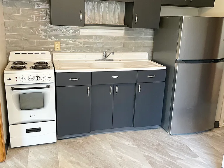Updated kitchen with new flooring and tiled backsplash.