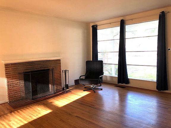 The Living/Dining area includes hardwood floors and a cozy wood-burning fireplace.