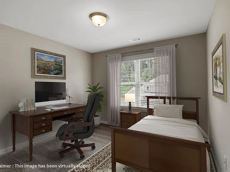 Versatile guest bedroom featuring a dedicated office space.