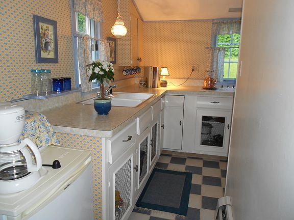 Galley kitchen equipped with coffee pot, microwave, toaster, pots & pans, dishes & silverware