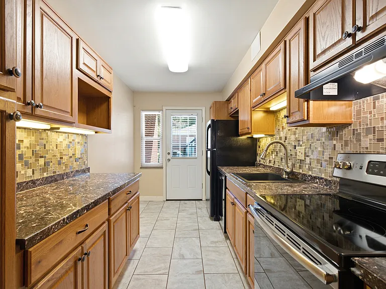 Good sized kitchen - looking from dining area. Tile floor. Entry from back door - easy to deal with groceries.