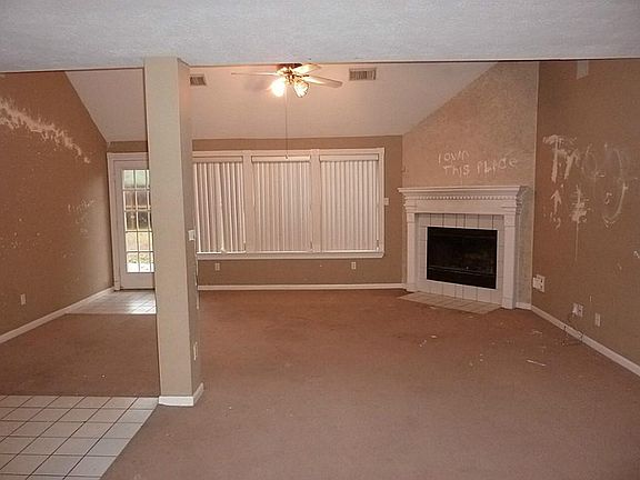 Den with corner gas log fireplace