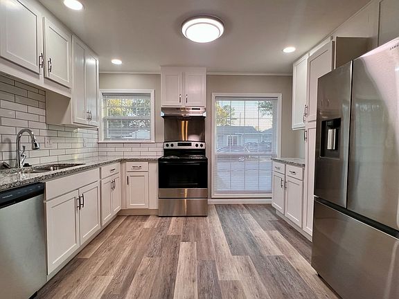 Renovated kitchen main view. Showing new cabinets, granite tops, appliances, flooring, paint and lighting. Large window lets in plenty of light.