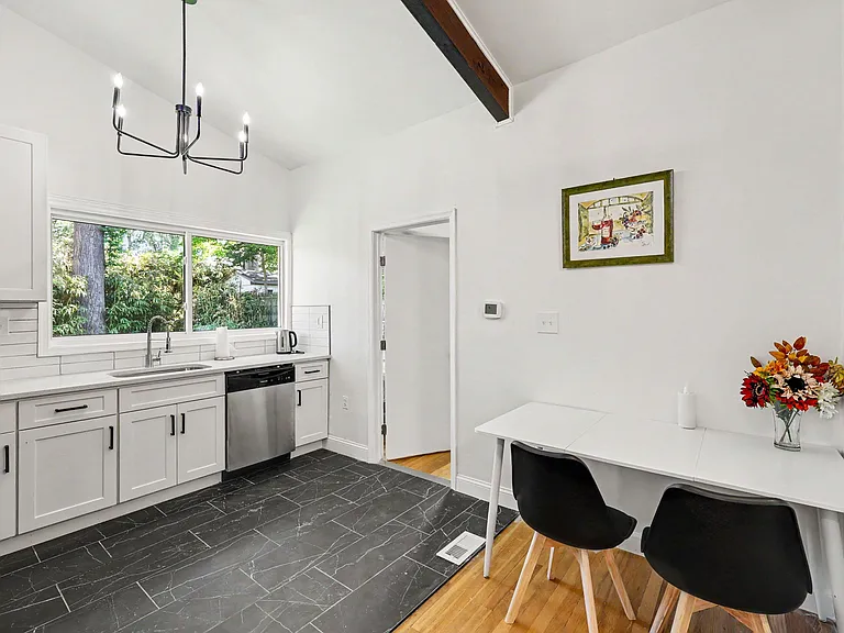 Open kitchen with generous counter space, dishwasher, and a sunny window over the sink plus an eat-in dining nook.
