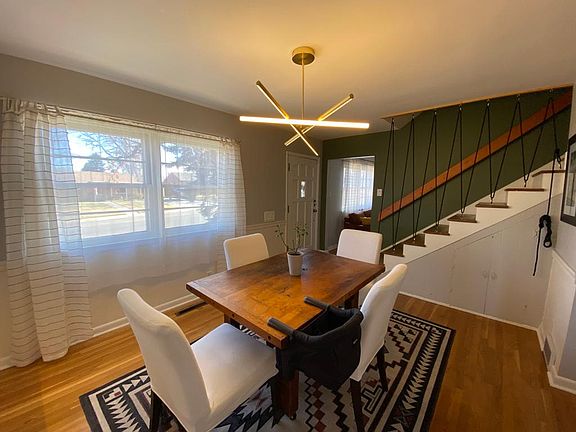 Large open dining area with contemporary light fixtures and staircase