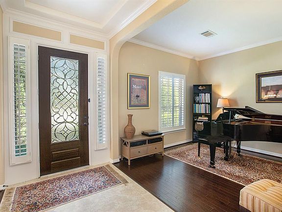 Beautiful tiled entry with leaded glass front door, tray ceiling, crown molding and plantation shutters.