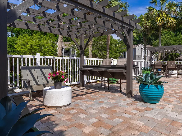 Unwind beneath the pergolas at The Enclave, offering a cozy, shaded spot for relaxing poolside in comfort.