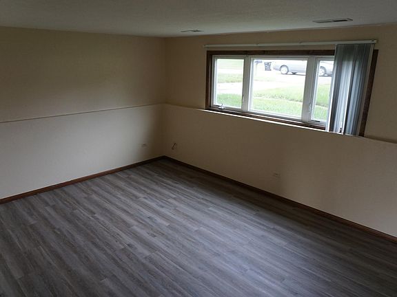 A large, semi-open living space with newer hardwood plank flooring throughout the unit.