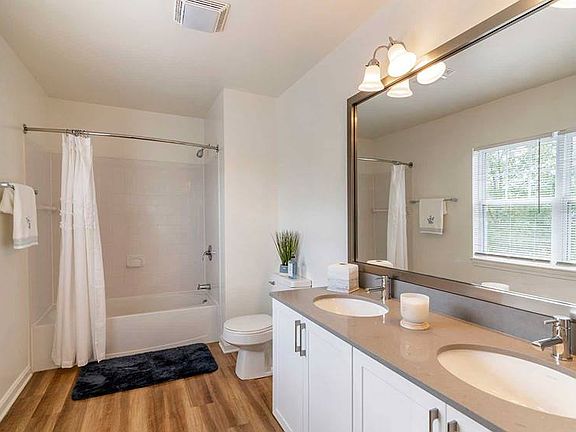 Newly renovated Finish Package II bath with white cabinetry, grey quartz countertops, and hard surface flooring