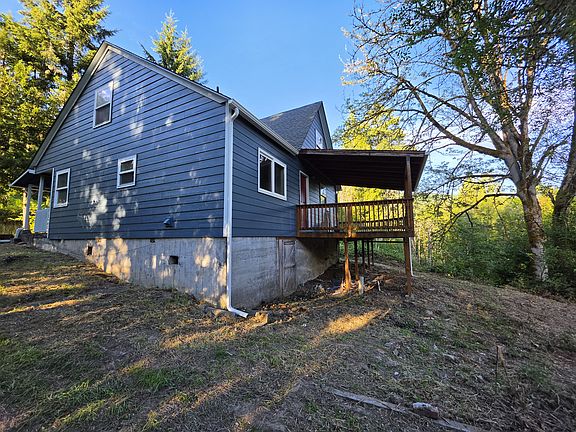 Rear of house, driveway side. Showing deck
Also shows a walk-in basement, which has a dirt floor