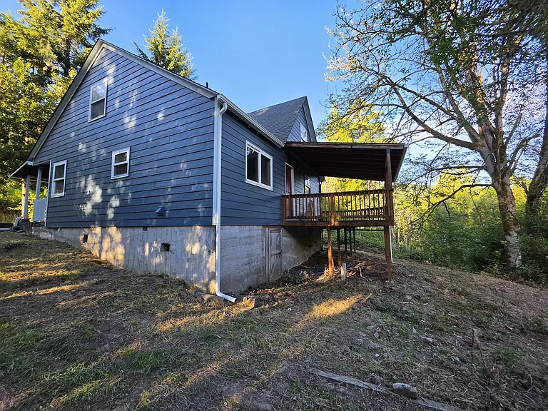 Rear of house, driveway side. Showing deck
Also shows a walk-in basement, which has a dirt floor