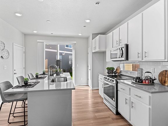 A view of the kitchen, island and doors to patio