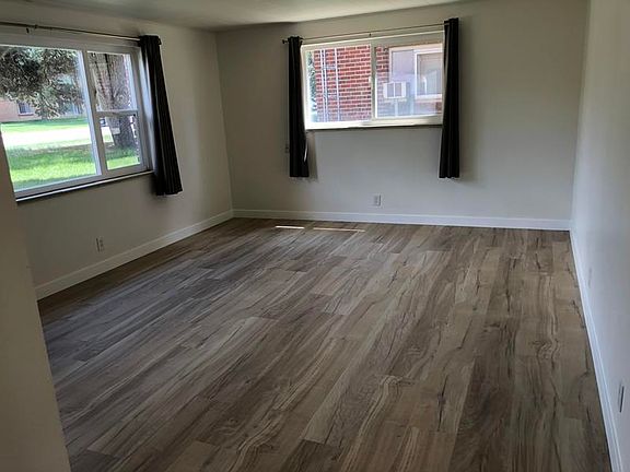 Living room has large windows for natural lighting and ventilation. New flooring.