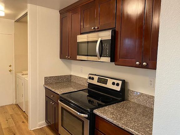 Kitchen part 1 and Laundry area next to Pantry. the Door opens to back of the Townhome into Car Port and Mail