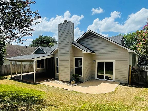 Fenced backyard with large covered patio and patio off of primary bedroom