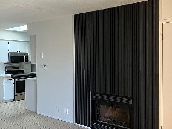 Designer touch slat wall surrounds wood burning fireplace.
