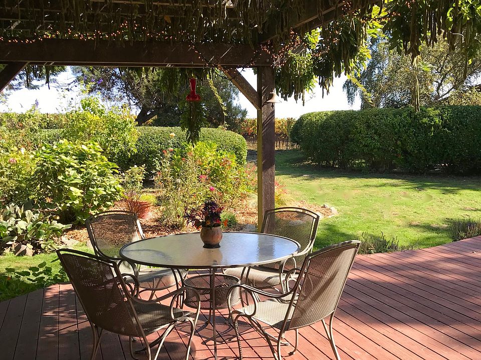 Wisteria-covered arbor on huge redwood deck with garden, yard and vineyard views.