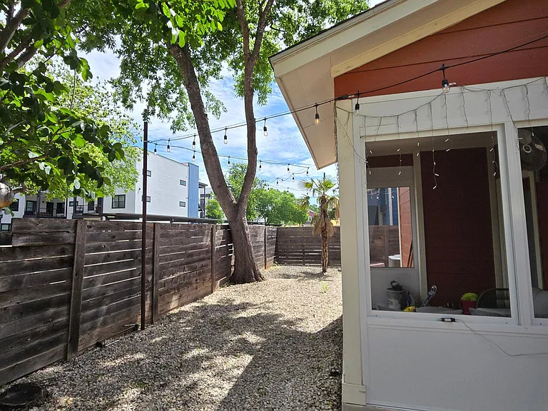 Fenced in backyard with cozy string lights (day view)