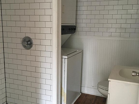 Bathroom with shower stall and washer/dryer.
