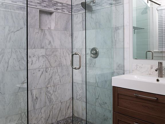This is the en-suite bathroom for the master bedroom. All marble flooring and marble shower tile to the ceiling. Deep drawers for storage of personal bathroom items. Plenty of room for hairdryers, make-up and more.