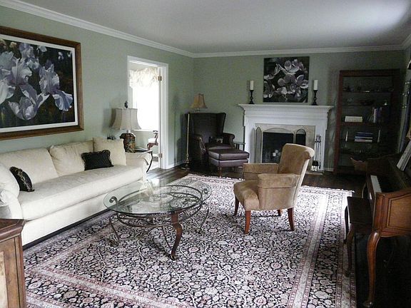 Living room has hardwood floors and a traditional fireplace