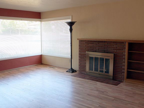 Living Room with large windows, fireplace, and built-in shelves.