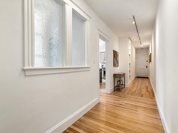 Reverse view of hallway, showing decorative glass windows of study.