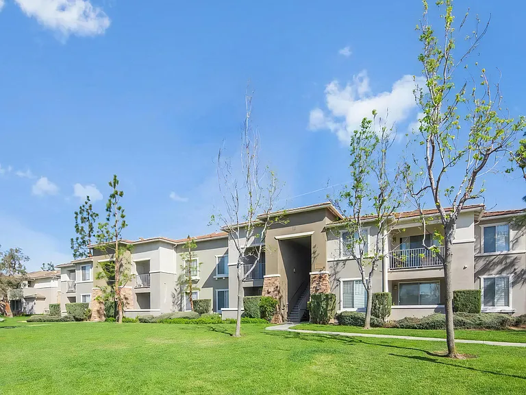 Camino Real Apartments Exterior with Tree-Lined Pathways and Manicured Lawn