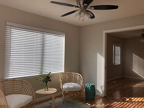 Living space with large windows, ceiling fan, that has a pocket door that opens into adjacent room for a larger living space, or can be closed to be used as a 4th bedroom (with large closet), office, work out space.