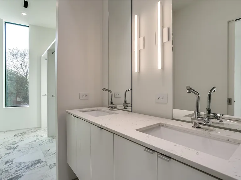 Double vanity featuring integrated sinks, chrome fixtures, and a light-toned countertop