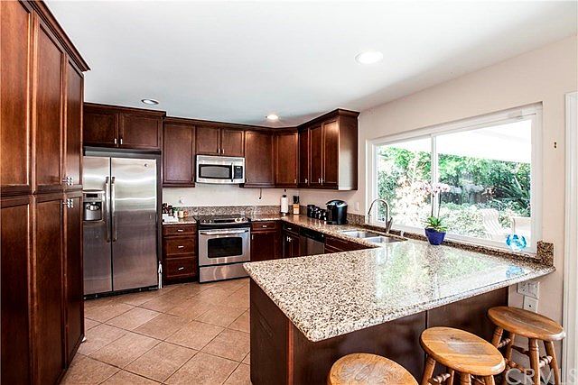 Remodeled kitchen with granite countertops, large window overlooking patio