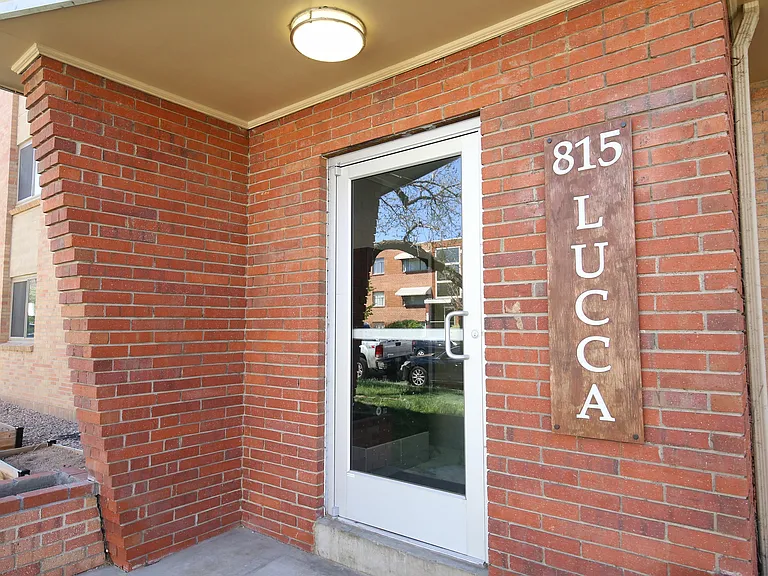 Inviting entrance with classic red brick design at Lucca apartment complex.