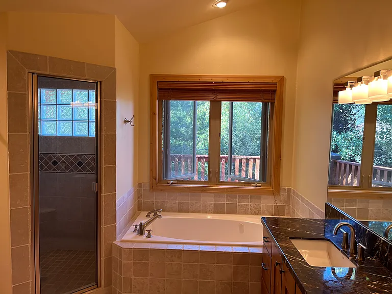 Primary bathroom has steam shower, jetted tub and dual vanities