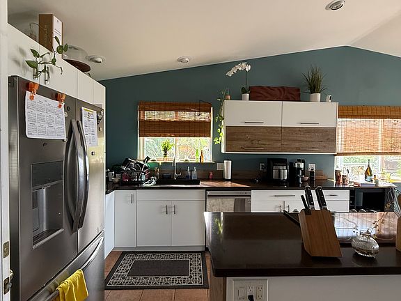 Recently remodeled kitchen showcasing rich dark-chocolate quartz countertops, crisp white cabinetry, and modern finishes