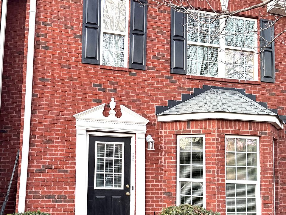 Two story brick home with bay window.