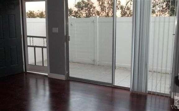 Fully enclosed patio at entry with sliding glass doors from living room onto same. Patio has been ti