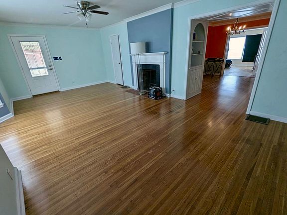 A wide living room with a bay window and storage closet.