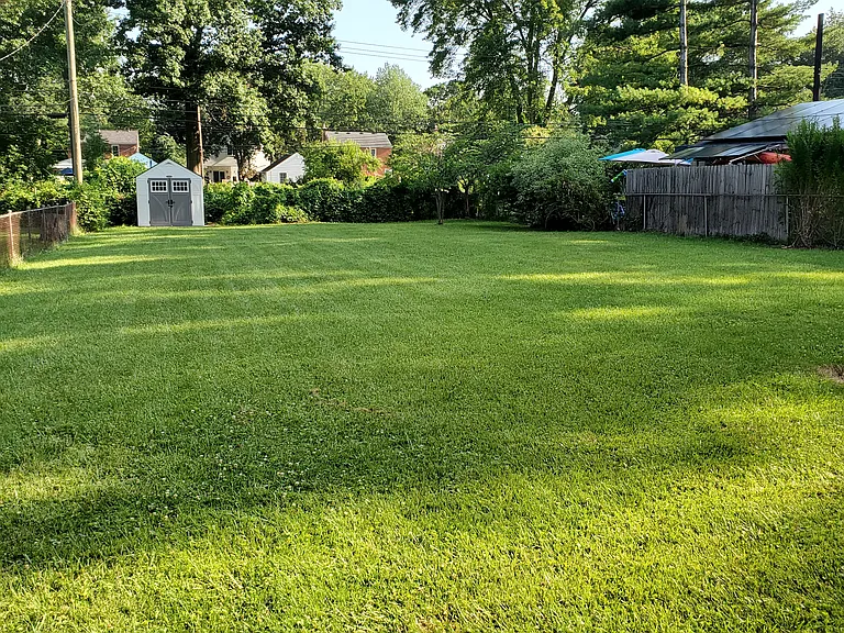 Fenced-in yard with patio and shed