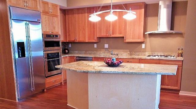 Stonebridge Lofts 1104 kitchen with granite countertops, hardwood floor and stainless steel appliances.