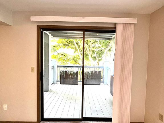 View of large private deck from the Living space, beautiful maple tree and pond just outside.