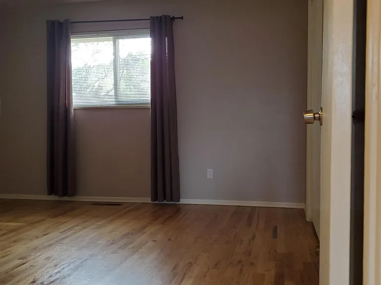 View of master bedroom. All three bedrooms have spacious closets the length of the room with slider doors and shelves. Hardwood floor has been replaced with new luxury vinyl flooring.