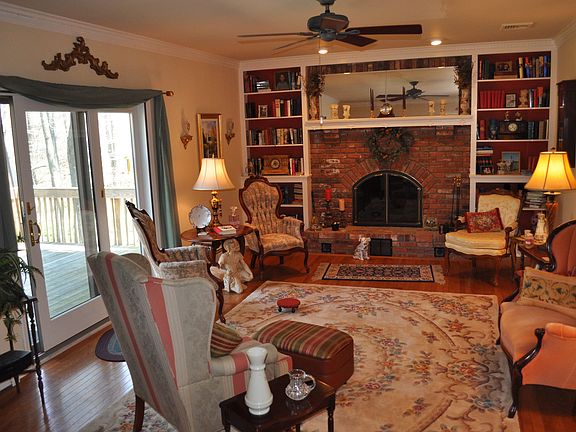 Family Room features Wood Burning Fireplace, Custom Wood Mantle & Book Shelves