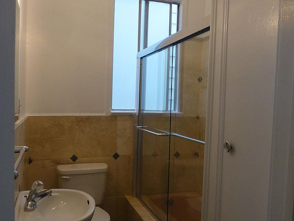 Bathroom with shower over tub and cabinet for toiletries.