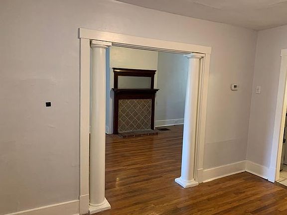 Dining room into living room. Notice decorative columns, fireplace accent and hardwood floors!