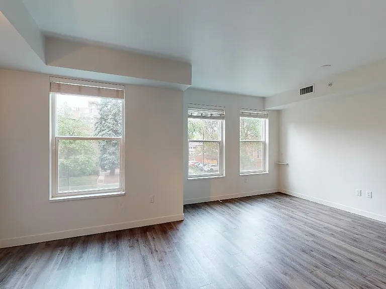 Apartment dining and living room with wood-style flooring.