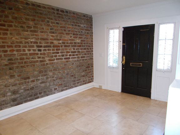 large entry with exposed brick wall & marble floor