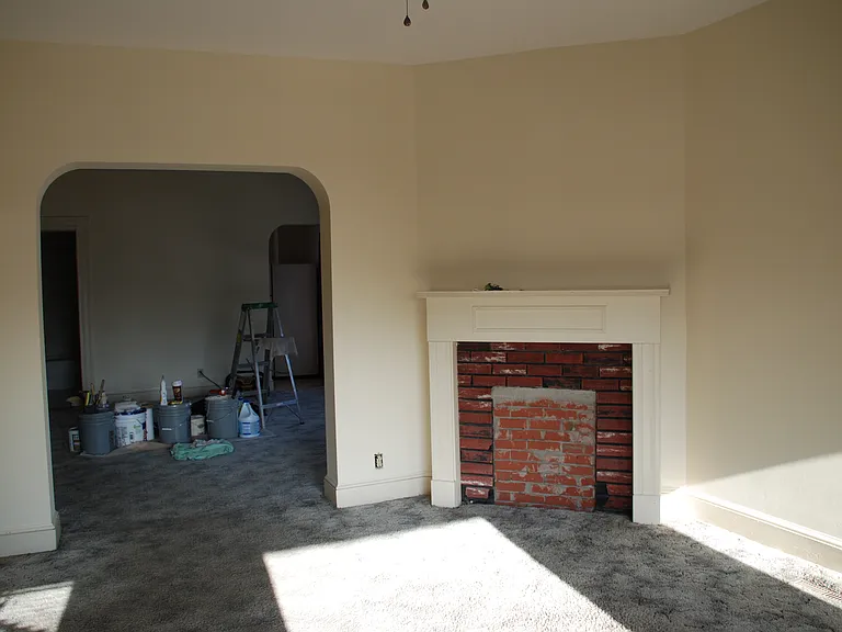 Living room mantel and looking into the dining room during a cleaning.