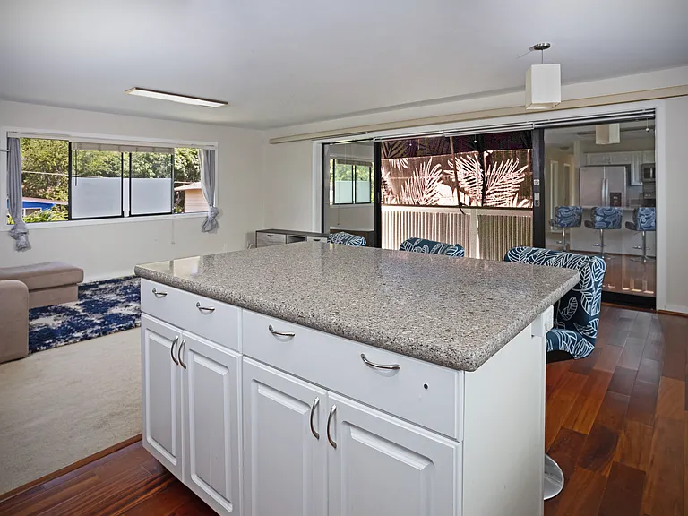 Stone Kitchen Island with 3 Barstools (Balcony in the Background)